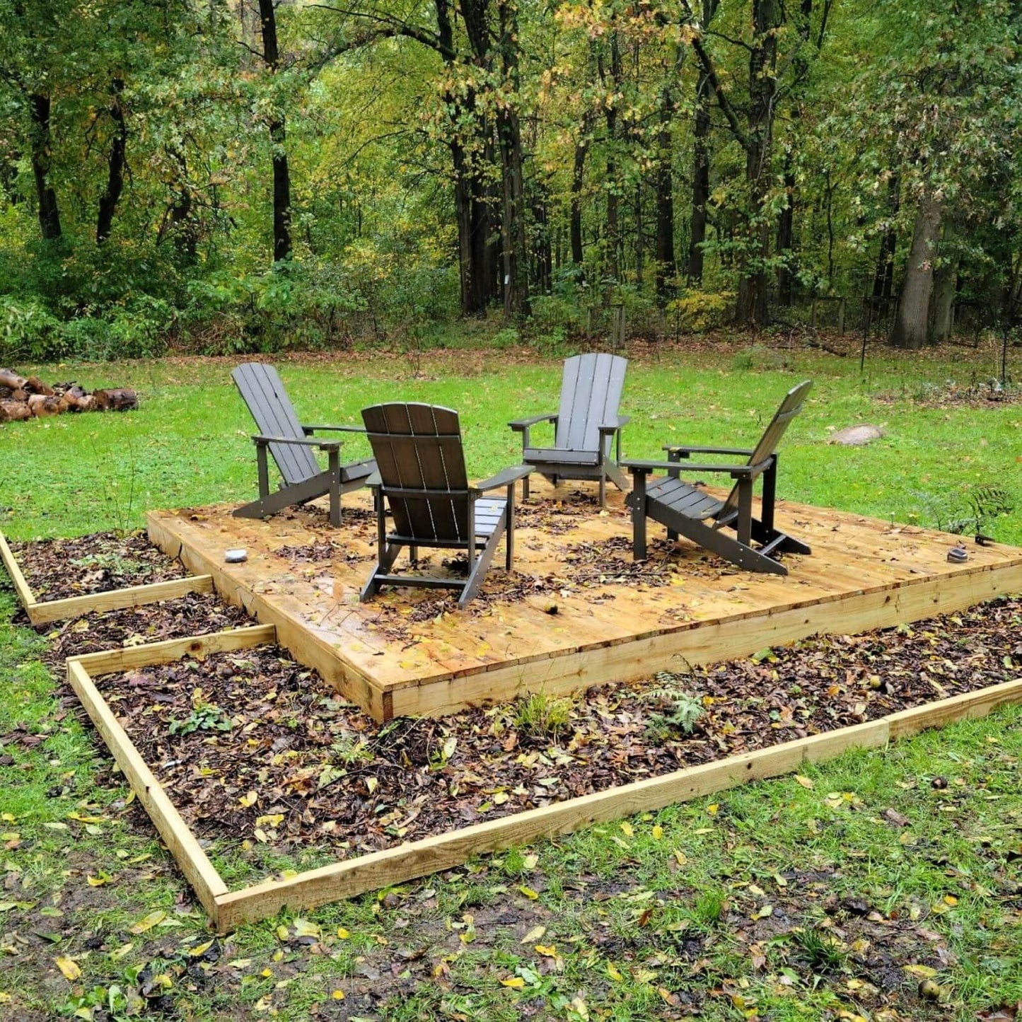 A floating deck surrounded with garden beds edged with 2xEDGE Rustic Steel Staples and 2x4 treated lumber.
