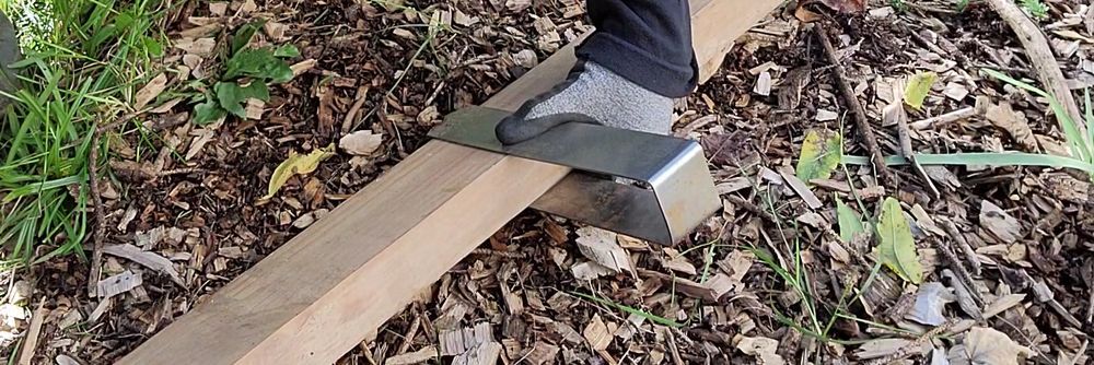 A demonstration of the correct way to grip a 2xEDGE Staple that's been placed over 2x4 lumber with a focus on where to place the thumb.