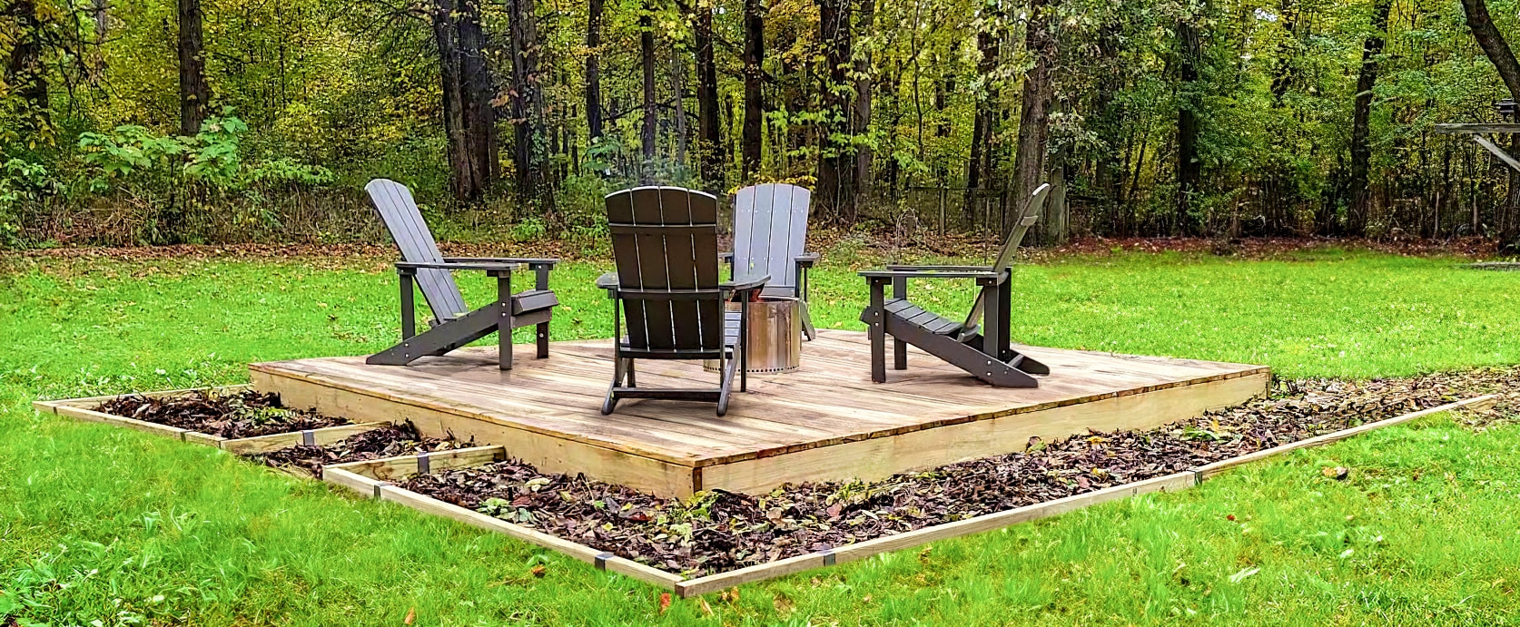 Deck charis on a wooden deck with garden beds around the deck edged with 2x4 lumber and 2xEDGE Staples.