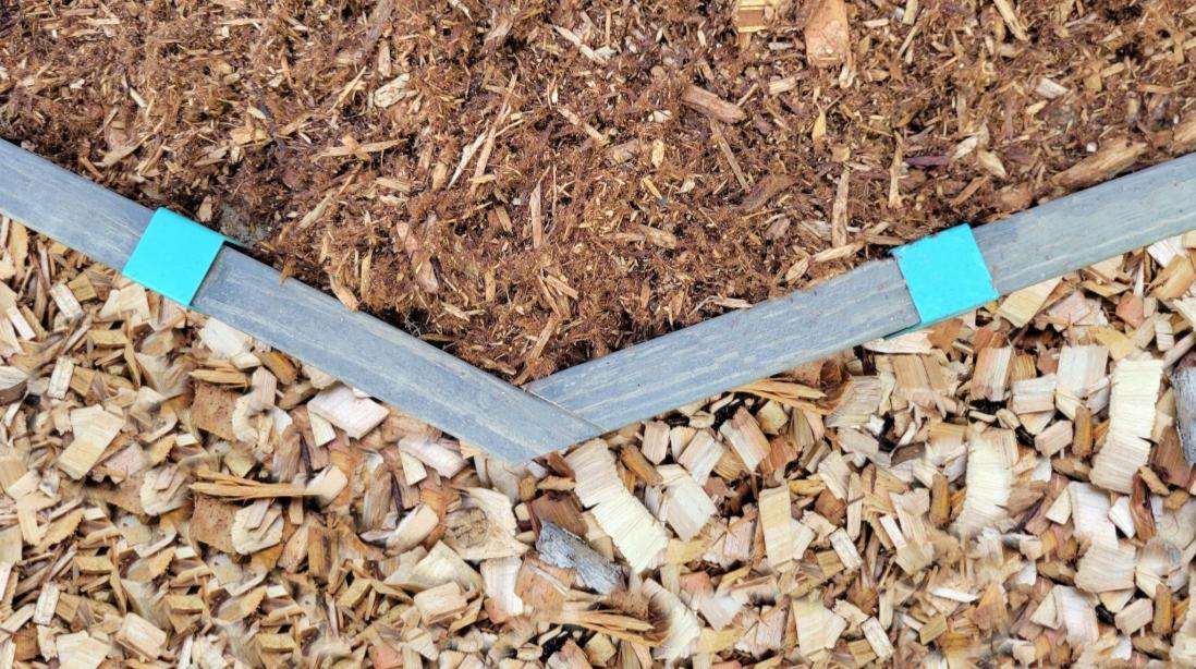 Wood edging keeping cedar mulch and large wood chips separated.