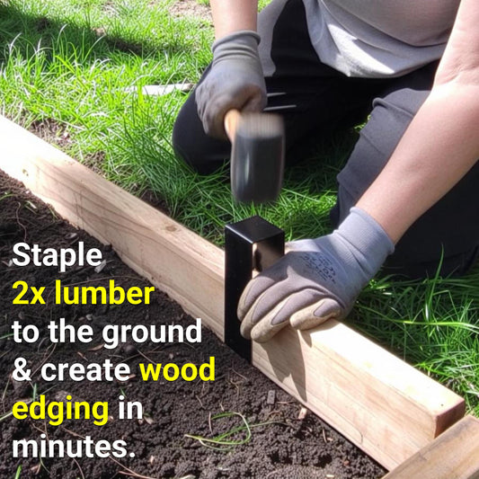 Gloved hands tapping a black 2xEDGE staple over 2x lumber with a rubber mallet to create wood garden edging in minutes. Text overlay: "Staple 2x lumber to the ground & create wood edging in minutes."