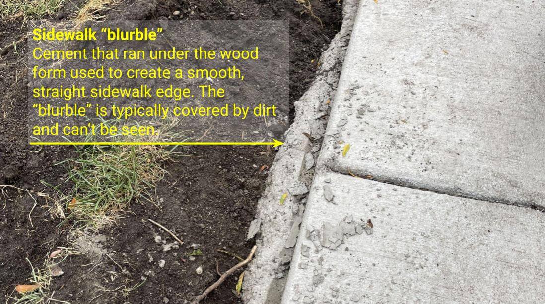 Cement that oozed out below the wooden form used to create a sidewalk.