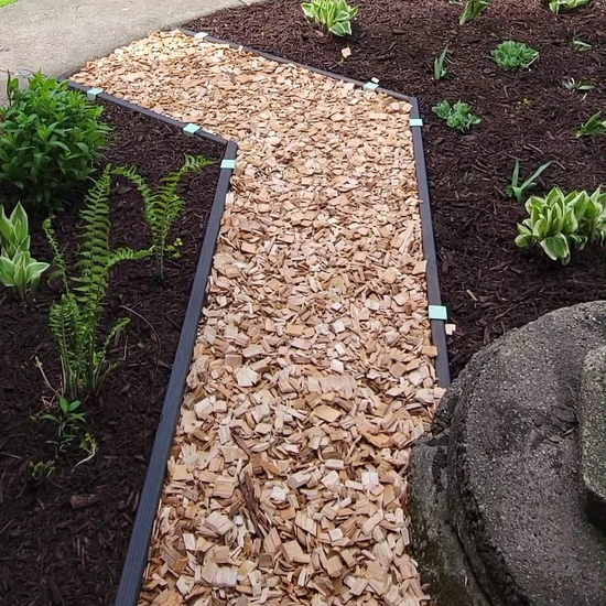 Dark walnut stained lumber installed as garden path edging with 2xEDGE.