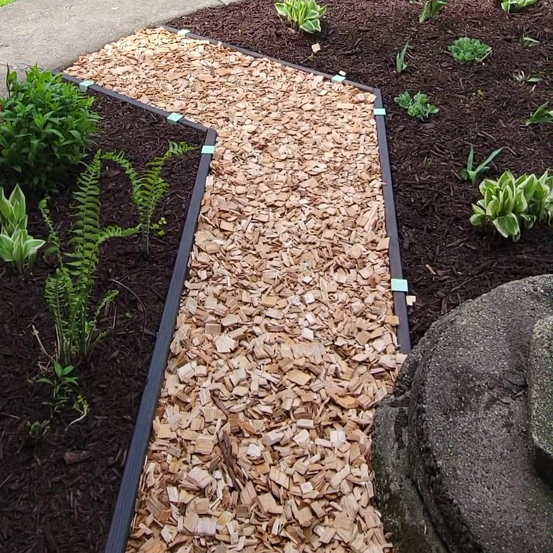 Dark walnut stained lumber installed as garden path edging with 2xEDGE.