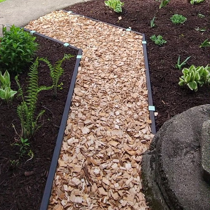 Dark walnut stained lumber installed as garden path edging with 2xEDGE.